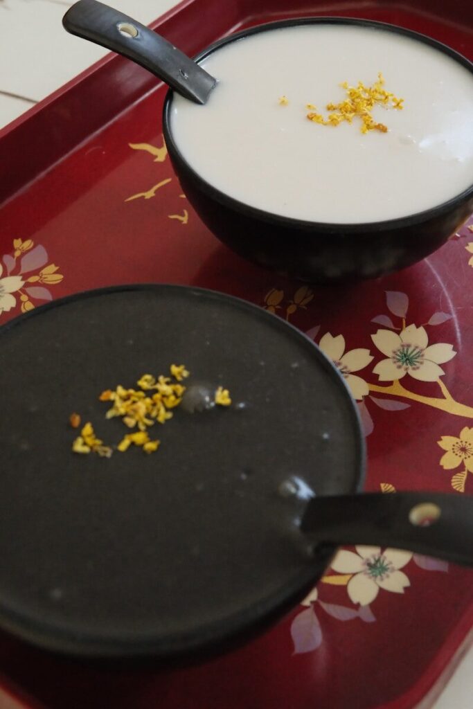 Two bowls of sweet soup with osmanthus flowers.