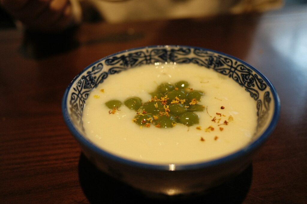 A blue and white bowl of soup on a table