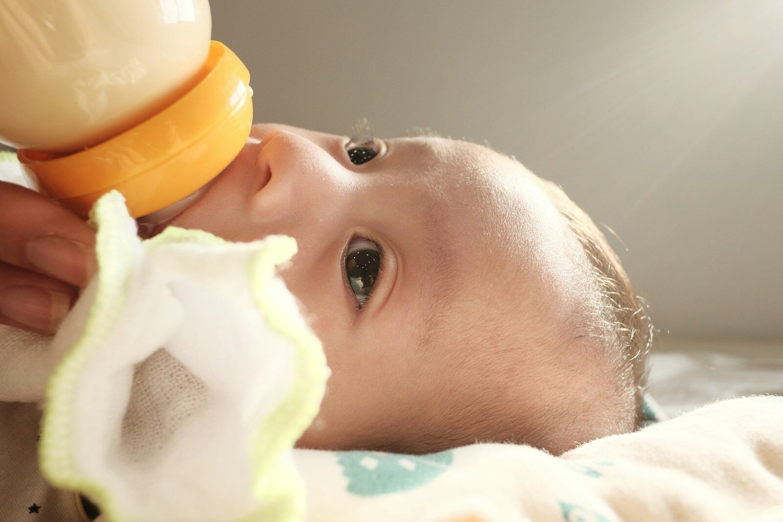 a baby laying on a bed with a pacifier in its mouth