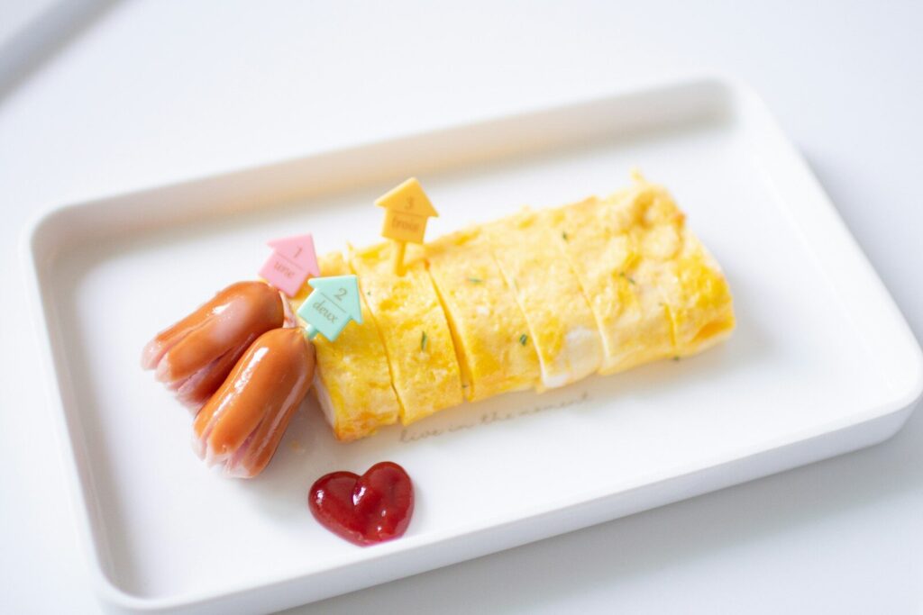 A plate features eggs, sausage and a heart