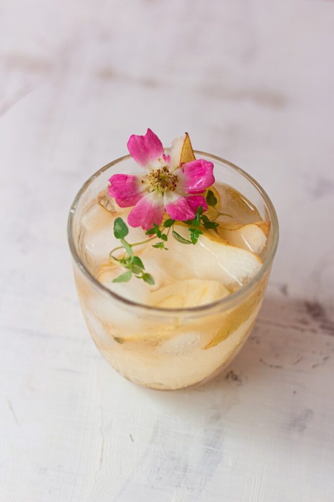 a glass of ice tea with a flower on top