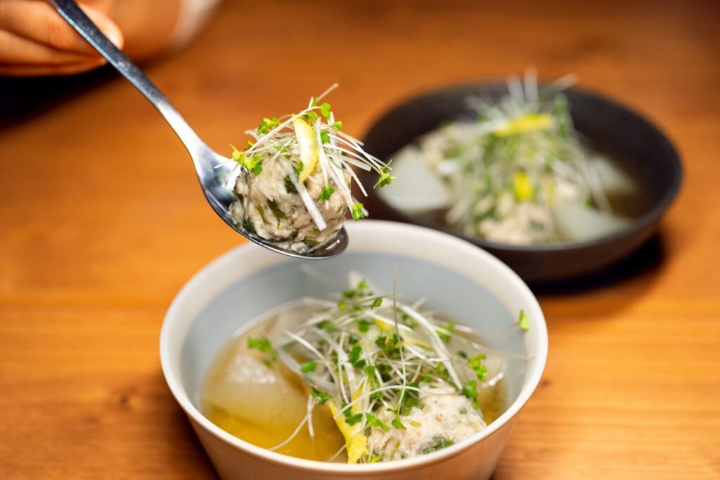 Savor the taste of fresh Asian soup with herbal garnish, perfect for gourmet enthusiasts.