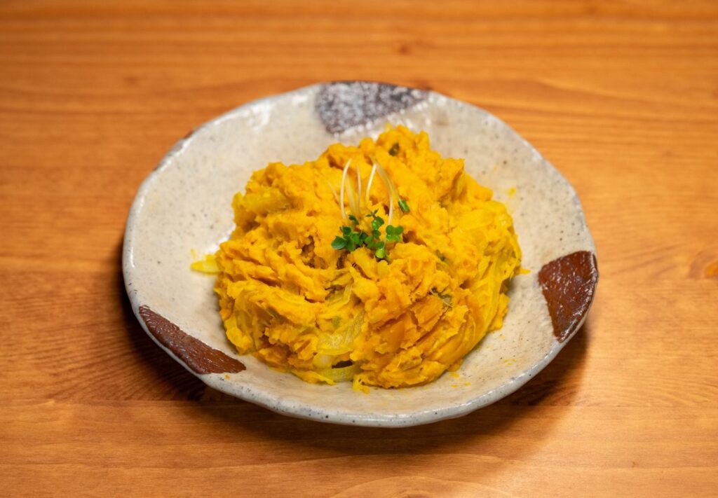 A delightful fusion of pumpkin and spices served in a traditional ceramic bowl, showcasing Asian culinary art.