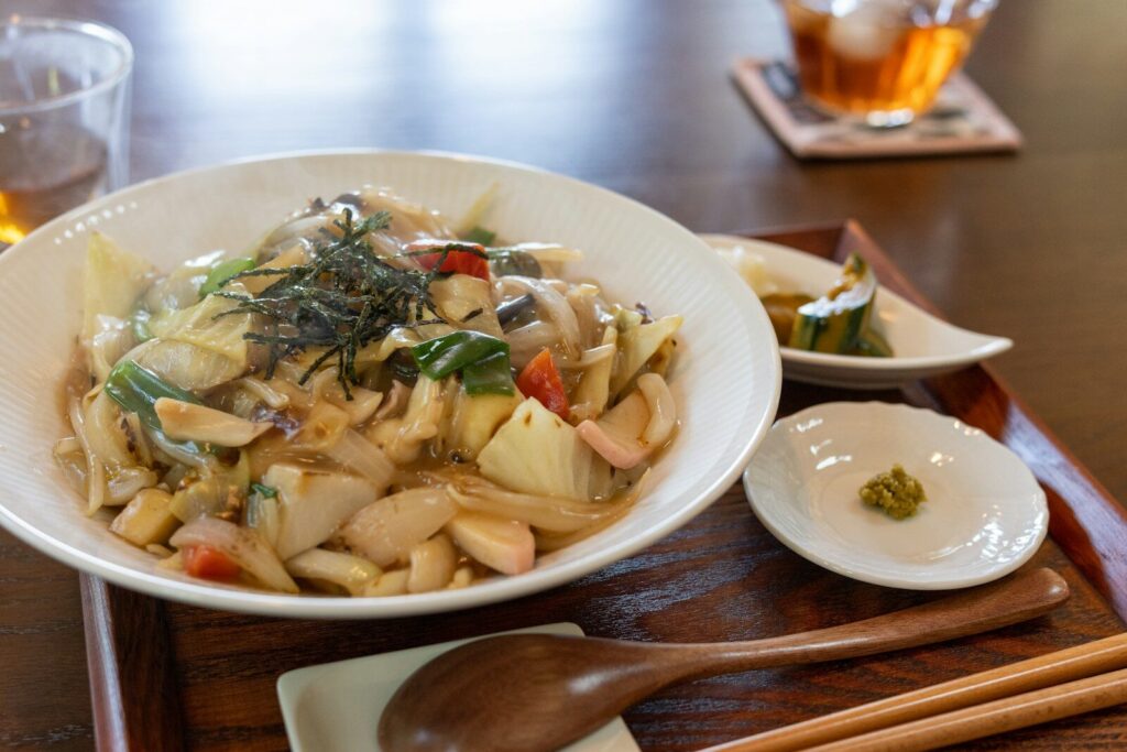 a bowl of food with chopsticks on a wooden tray